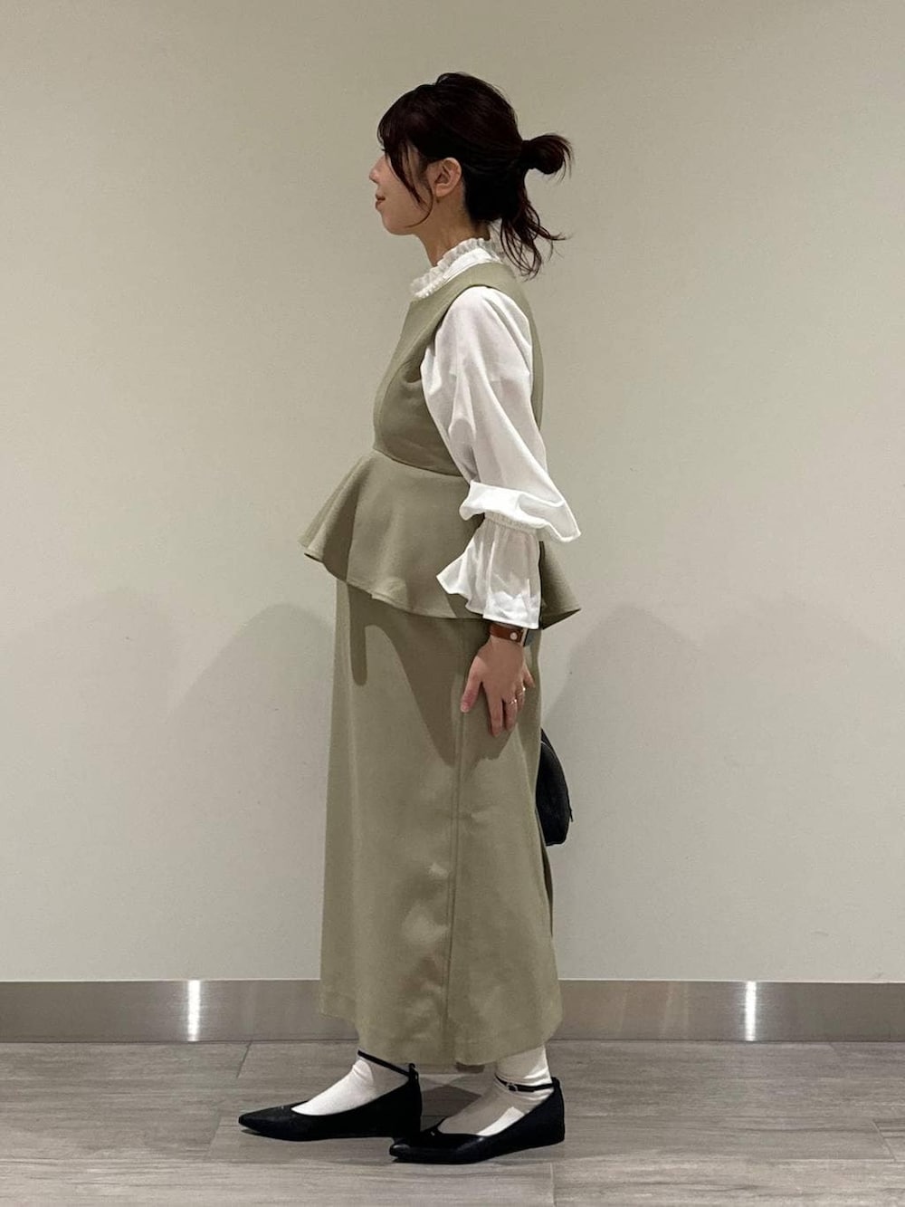 ブラック系のハンドバッグ、ベージュ系のワンピース、ホワイト系のシャツ/ブラウスを着用したレディースの冬コーディネートの3枚目の写真