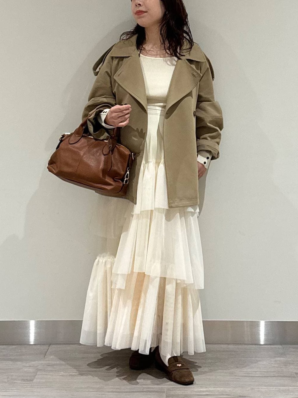 ブラウン系のボストンバッグ、ブラウン系のローファー、ホワイト系のスカートを着用したレディースの冬コーディネートの5枚目の写真