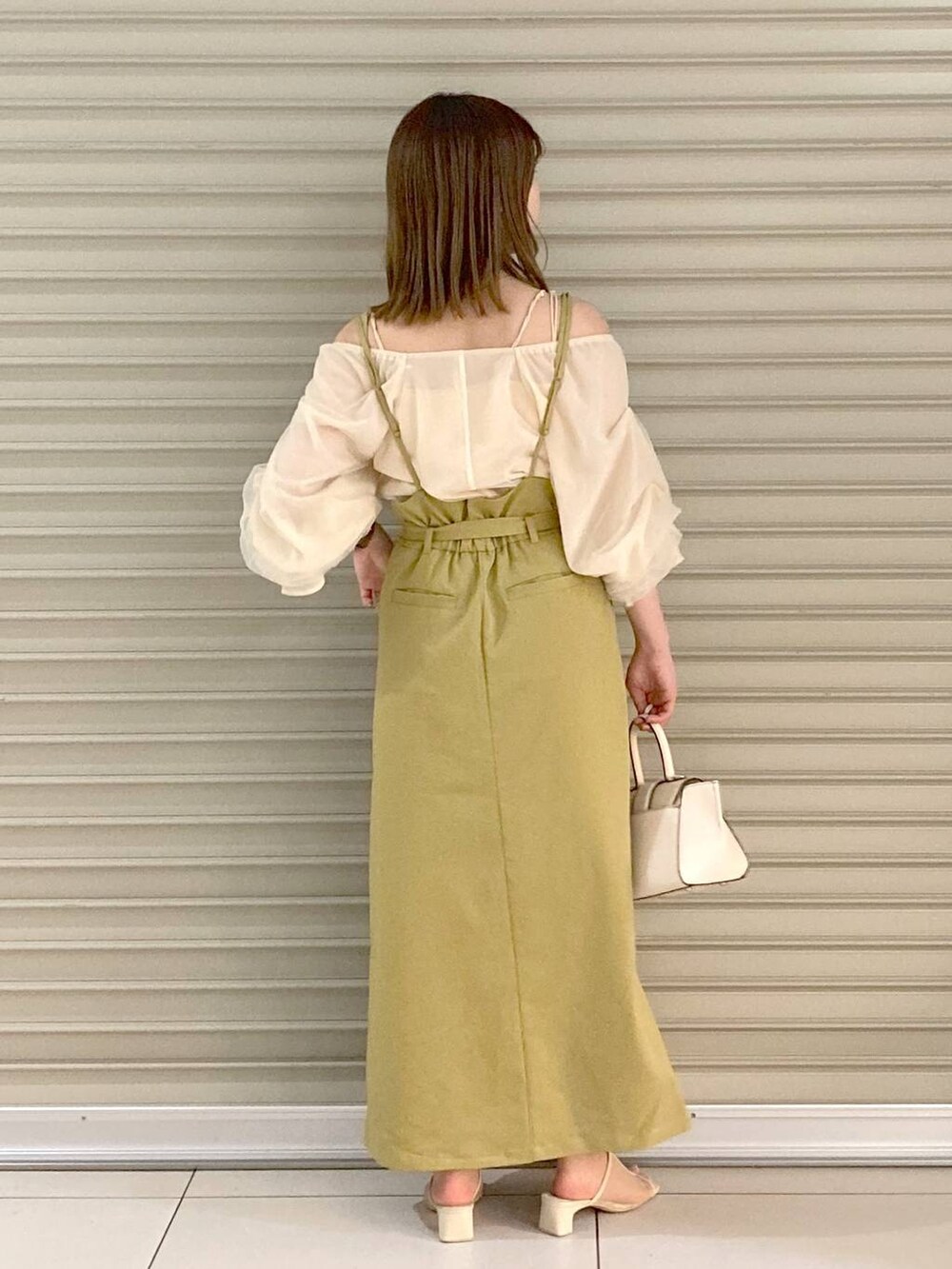 ホワイト系のサンダル、ホワイト系のシャツ/ブラウス、ホワイト系のハンドバッグを着用したレディースの夏コーディネートの3枚目の写真