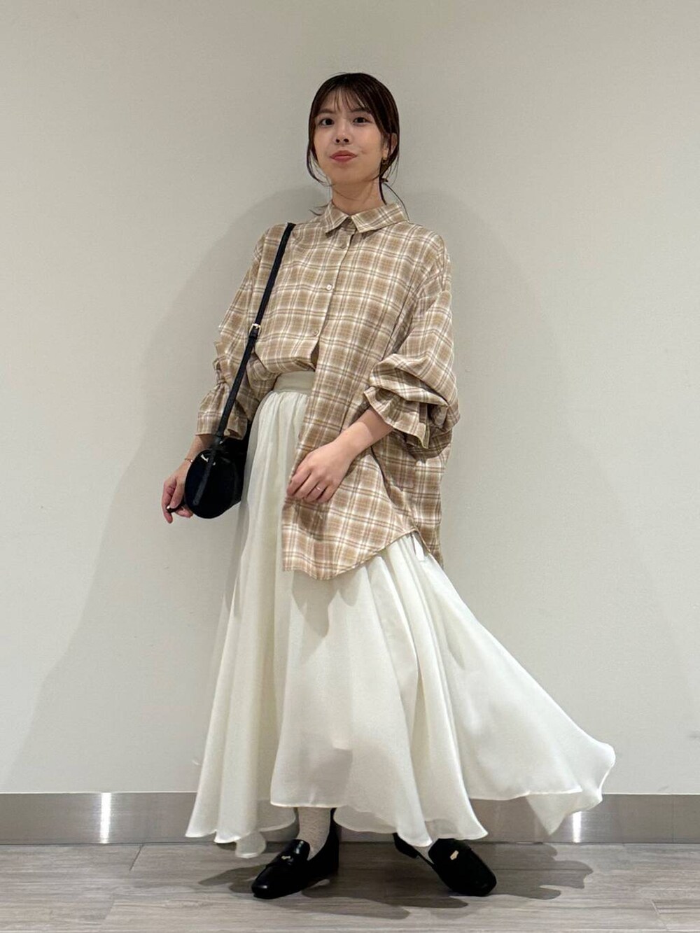 ベージュ系のシャツ/ブラウス、ブラック系のショルダーバッグ、ホワイト系のスカートを着用したレディースの秋コーディネートの4枚目の写真