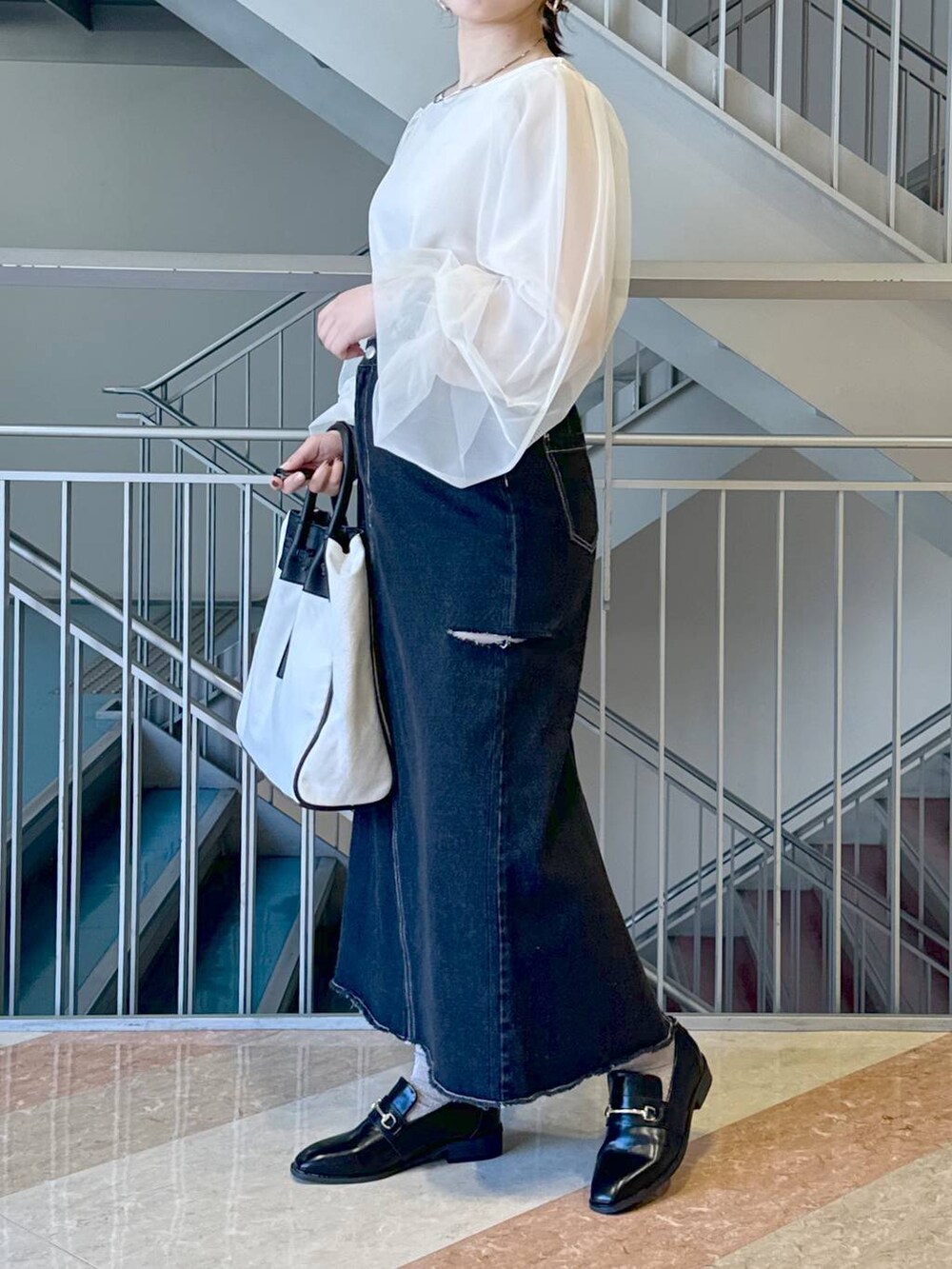 ブラック系のトートバッグ、ブラック系のローファー、ブラック系のスカートを着用したレディースの冬コーディネートの2枚目の写真