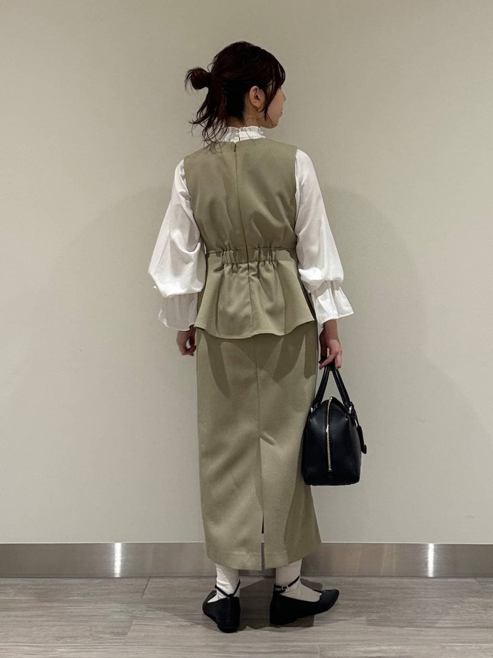 ブラック系のハンドバッグ、ベージュ系のワンピース、ホワイト系のシャツ/ブラウスを着用したレディースの冬コーディネートの4枚目の写真