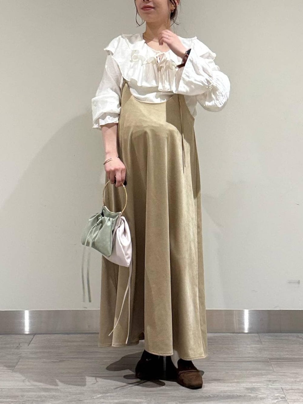 ブラウン系のローファー、ホワイト系のシャツ/ブラウス、ベージュ系のワンピースを着用したレディースの春コーディネートの2枚目の写真