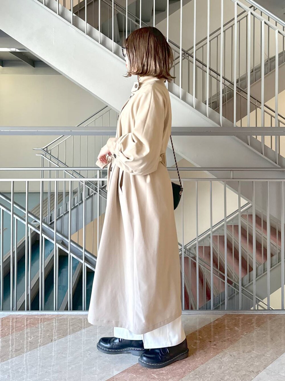 グレー系のニット/セーター、ブラック系のショルダーバッグ、ホワイト系のその他パンツを着用したレディースの春コーディネートの3枚目の写真