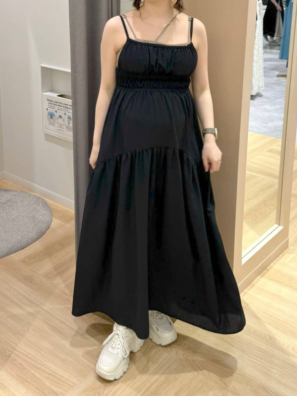 ブラック系のワンピース、ホワイト系のスニーカーを着用したレディースの夏コーディネートの5枚目の写真