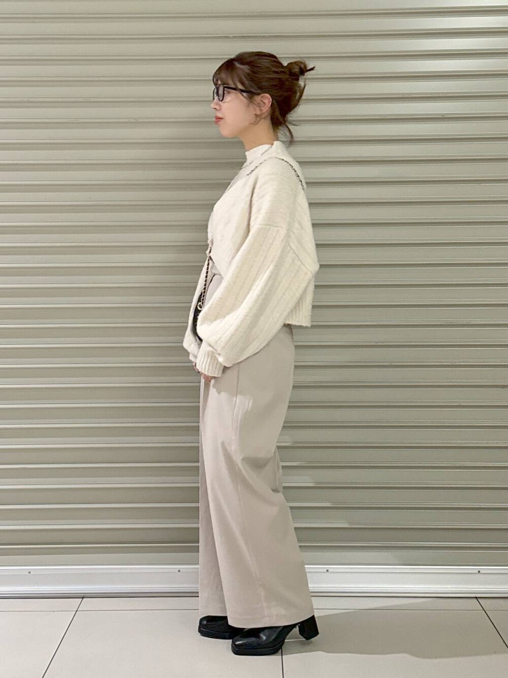 ブラック系のショルダーバッグ、ブラック系のブーツ、ホワイト系のその他パンツを着用したレディースの秋コーディネートの5枚目の写真