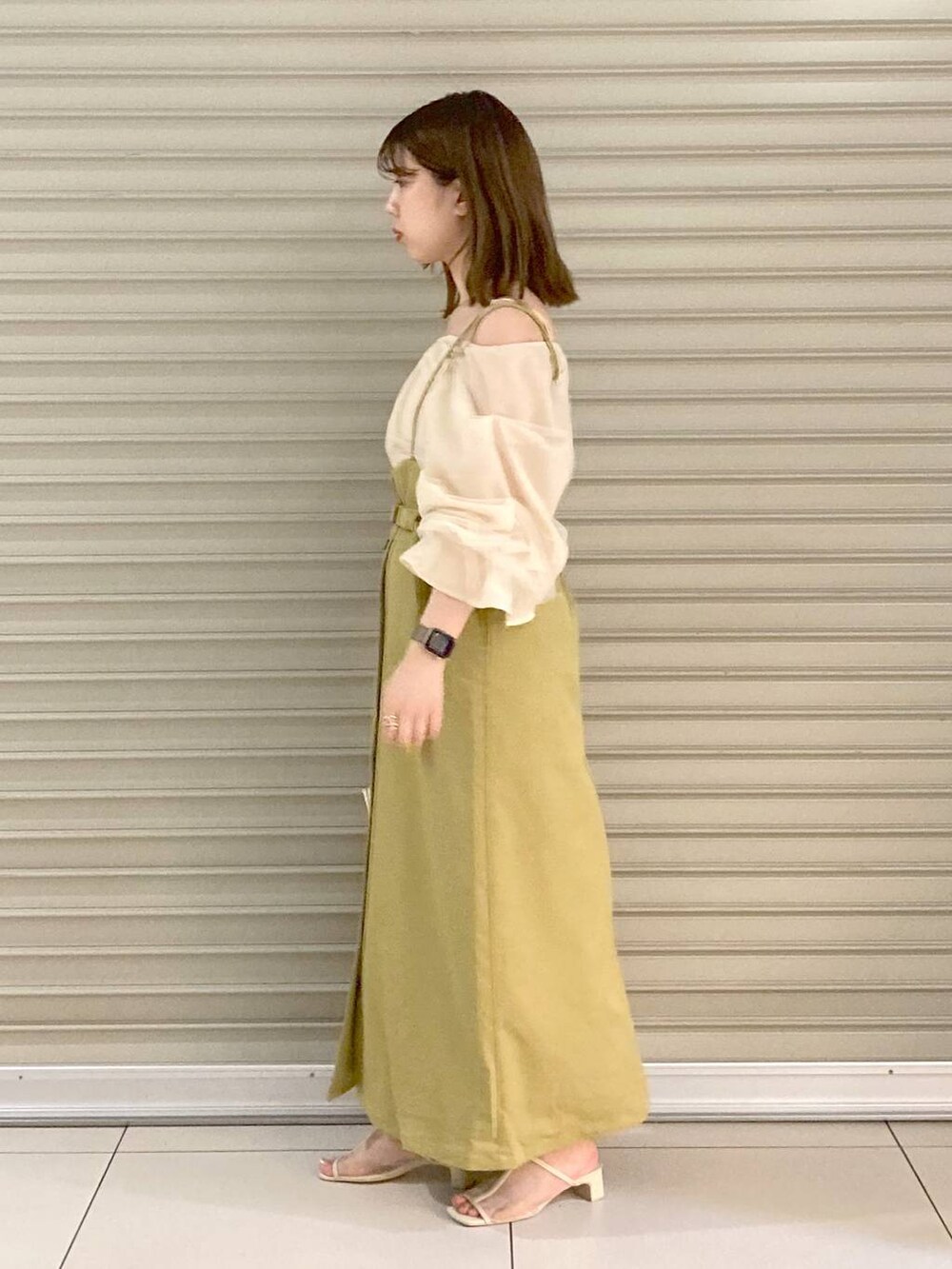 ホワイト系のサンダル、ホワイト系のシャツ/ブラウス、ホワイト系のハンドバッグを着用したレディースの夏コーディネートの2枚目の写真