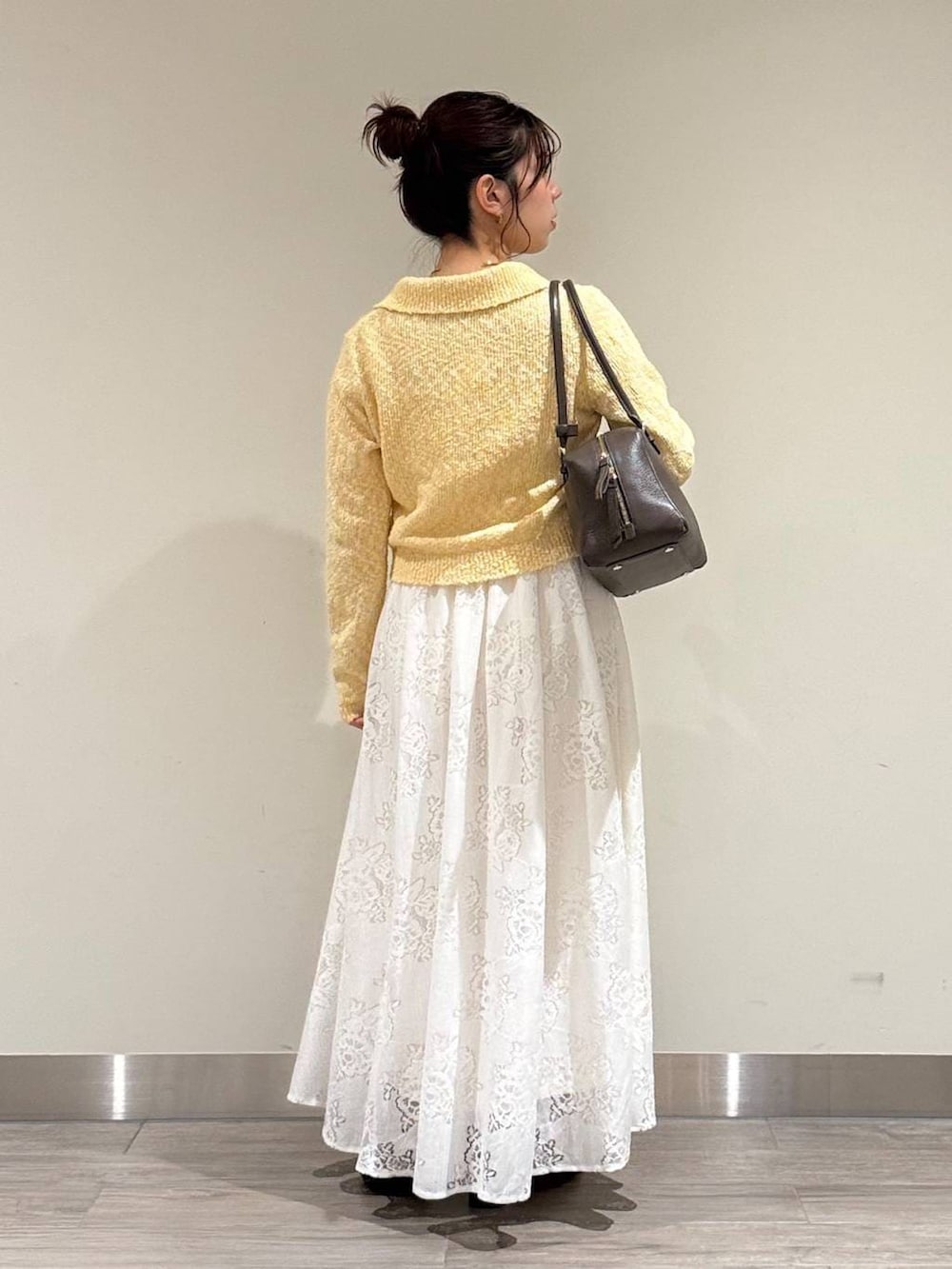 ブラウン系のハンドバッグ、ブラウン系のローファー、ホワイト系のワンピースを着用したレディースの春コーディネートの3枚目の写真