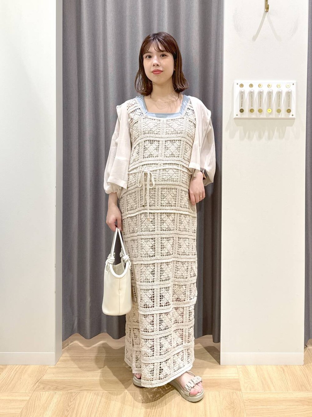 グレー系のサンダル、ホワイト系のハンドバッグ、ブルー系のタンクトップを着用したレディースの夏コーディネートの4枚目の写真