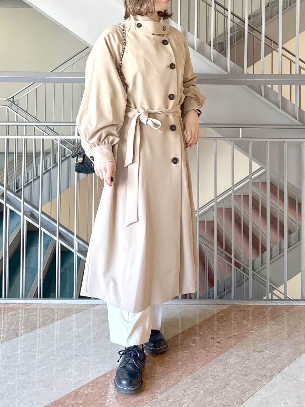 グレー系のニット/セーター、ブラック系のショルダーバッグ、ホワイト系のその他パンツを着用したレディースの春コーディネートの5枚目の写真