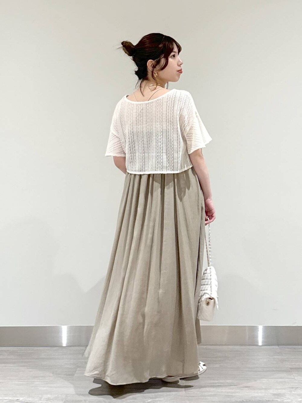 ホワイト系のカーディガン/ボレロ、グリーン系のワンピース、ホワイト系のショルダーバッグを着用したレディースの夏コーディネートの2枚目の写真