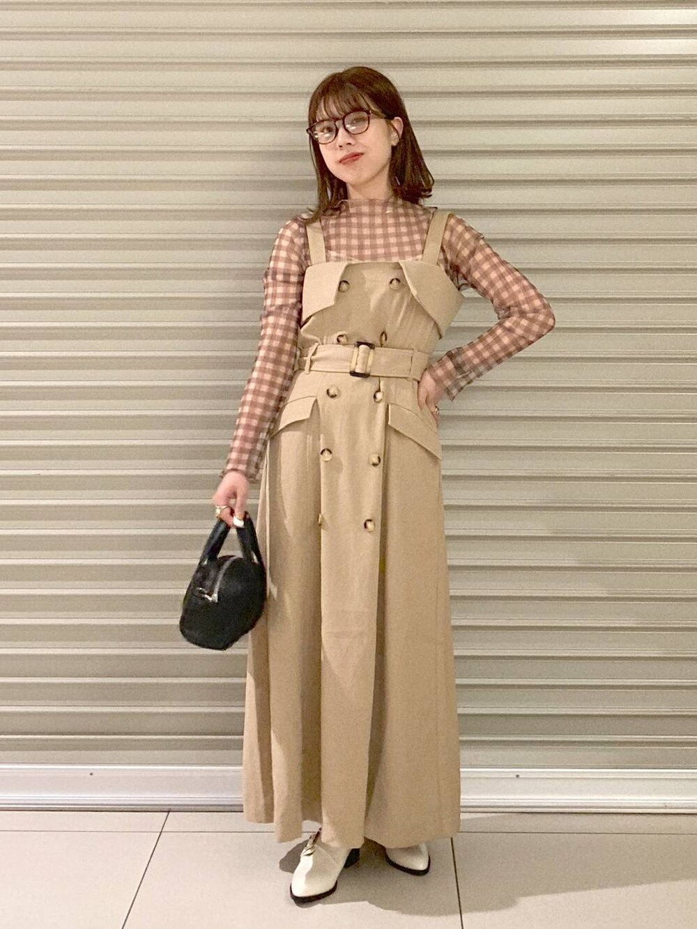 ブラック系のボストンバッグ、ホワイト系のその他シューズ、ベージュ系のジャンパースカートを着用したレディースの夏コーディネートの2枚目の写真