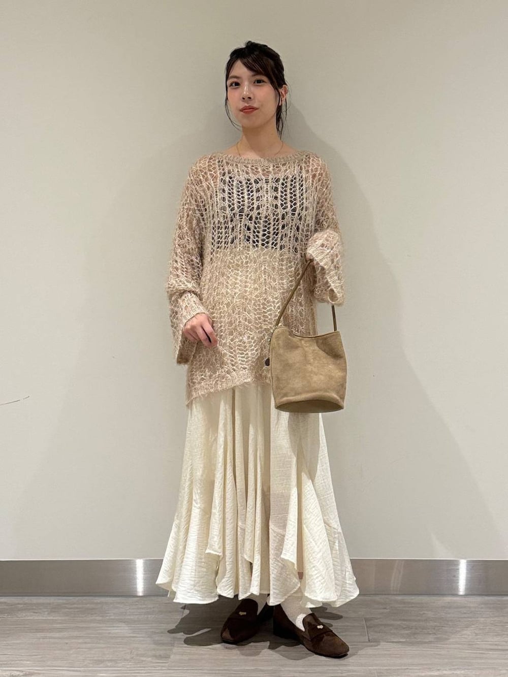 ベージュ系のニット/セーター、ホワイト系のスカート、ブラウン系のローファーを着用したレディースの秋コーディネートの2枚目の写真