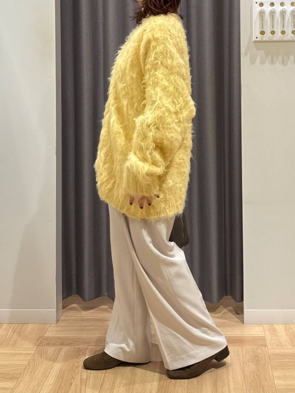 ブラウン系のハンドバッグ、イエロー系のカーディガン/ボレロ、ブラウン系のローファーを着用したレディースの秋コーディネートの4枚目の写真