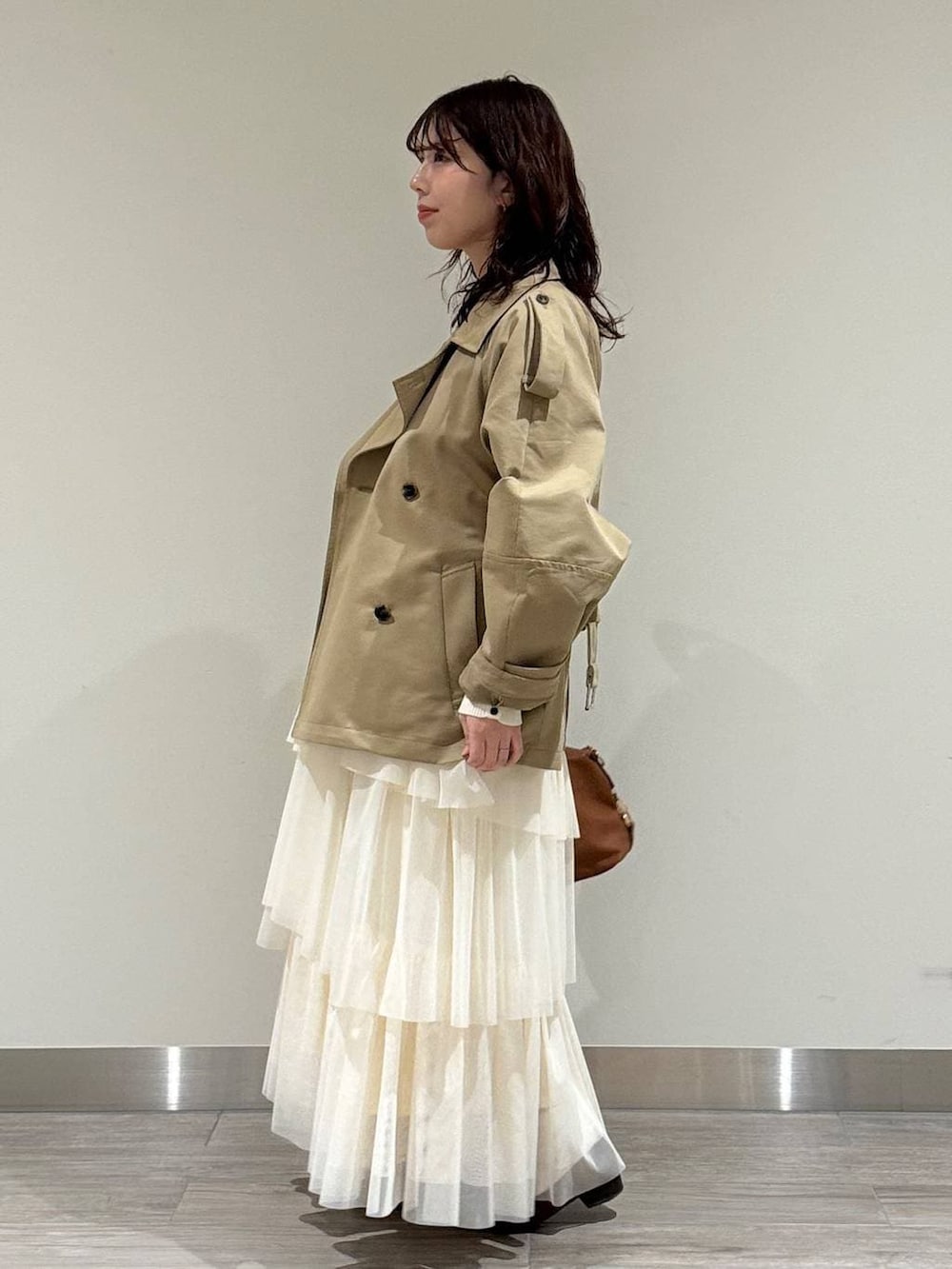 ブラウン系のボストンバッグ、ブラウン系のローファー、ホワイト系のスカートを着用したレディースの冬コーディネートの4枚目の写真