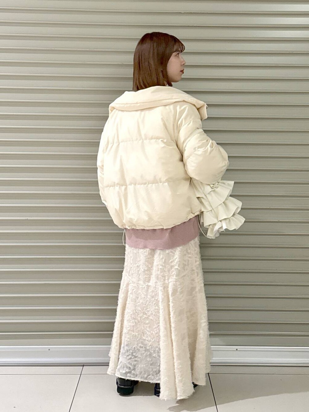 ブラック系のブーツ、ピンク系のニット/セーター、ホワイト系のトートバッグを着用したレディースの冬コーディネートの3枚目の写真