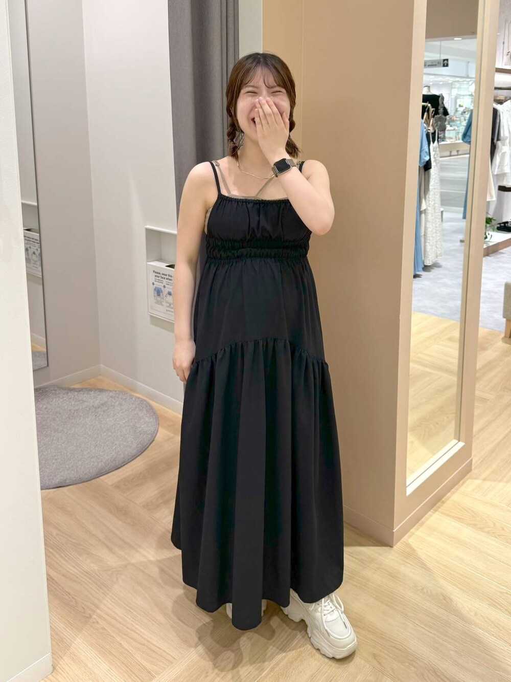 ブラック系のワンピース、ホワイト系のスニーカーを着用したレディースの夏コーディネートの2枚目の写真