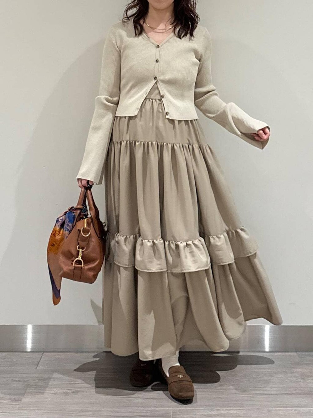 ブラウン系のボストンバッグ、ホワイト系のキャミソール、ブラウン系のローファーを着用したレディースの冬コーディネートの2枚目の写真