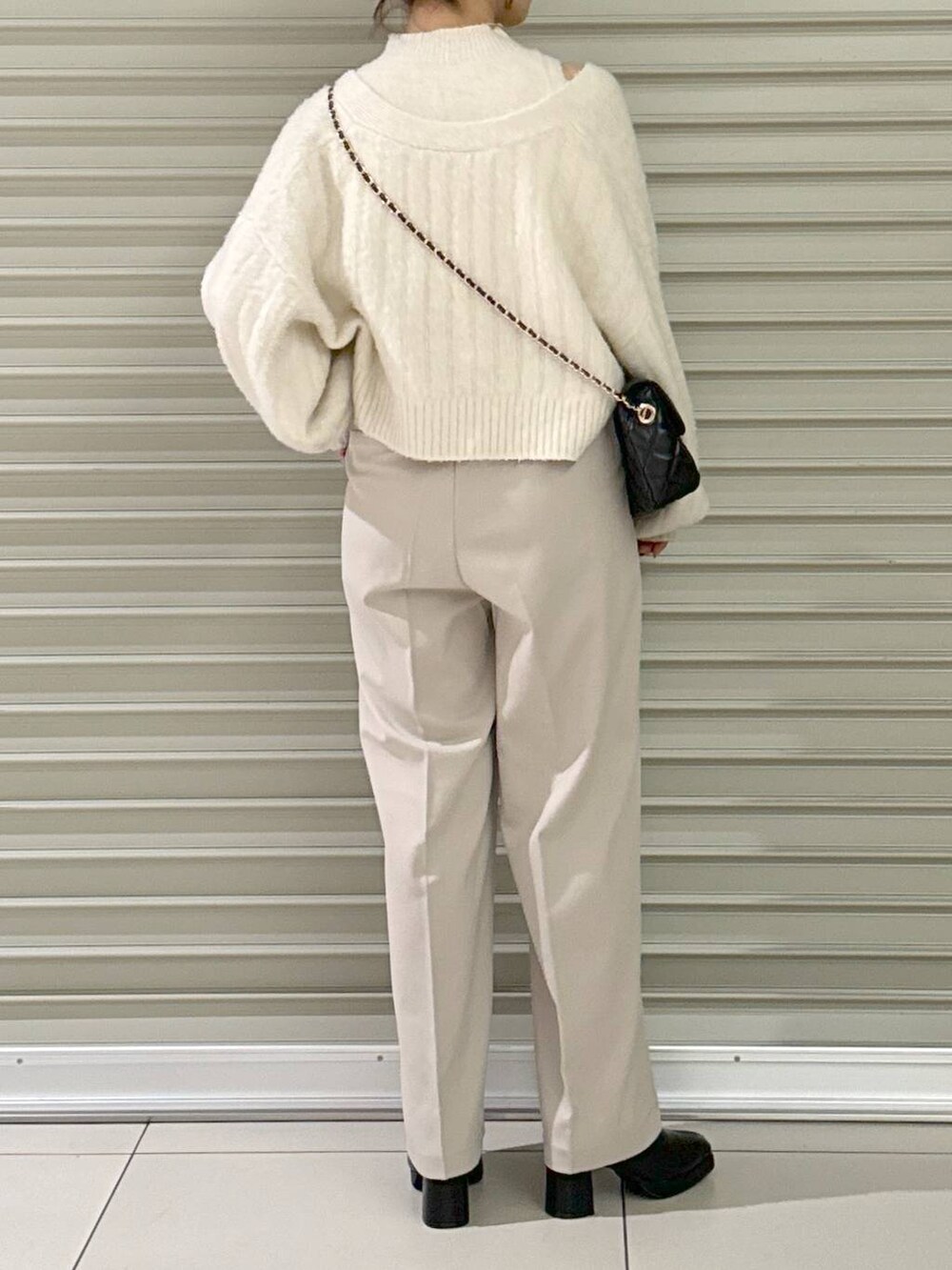 ブラック系のショルダーバッグ、ブラック系のブーツ、ホワイト系のその他パンツを着用したレディースの秋コーディネートの3枚目の写真