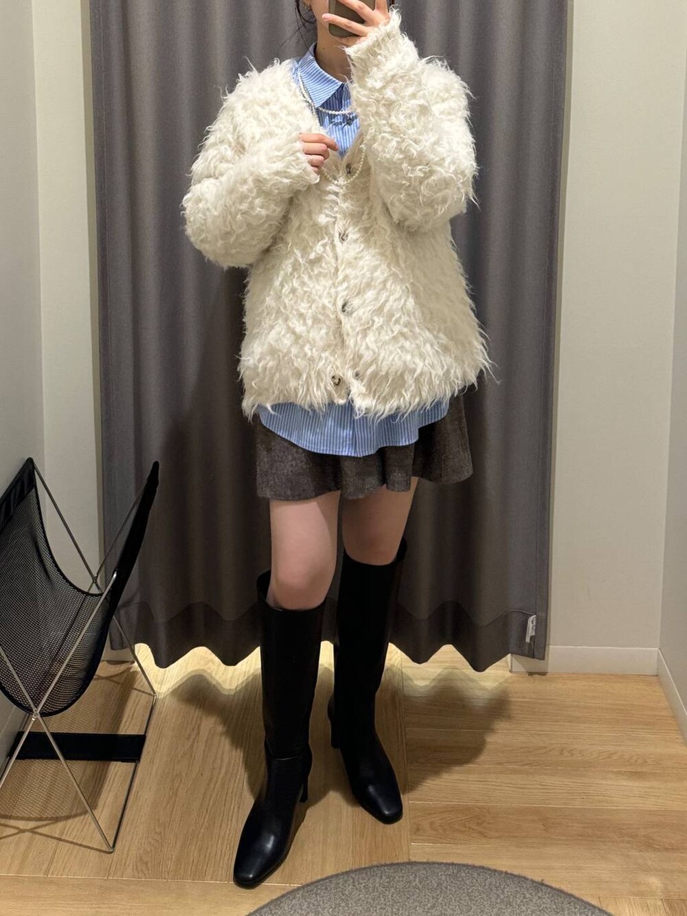 ブラウン系のボストンバッグ、ホワイト系のカーディガン/ボレロ、ブラウン系のその他パンツを着用したレディースの冬コーディネートの2枚目の写真