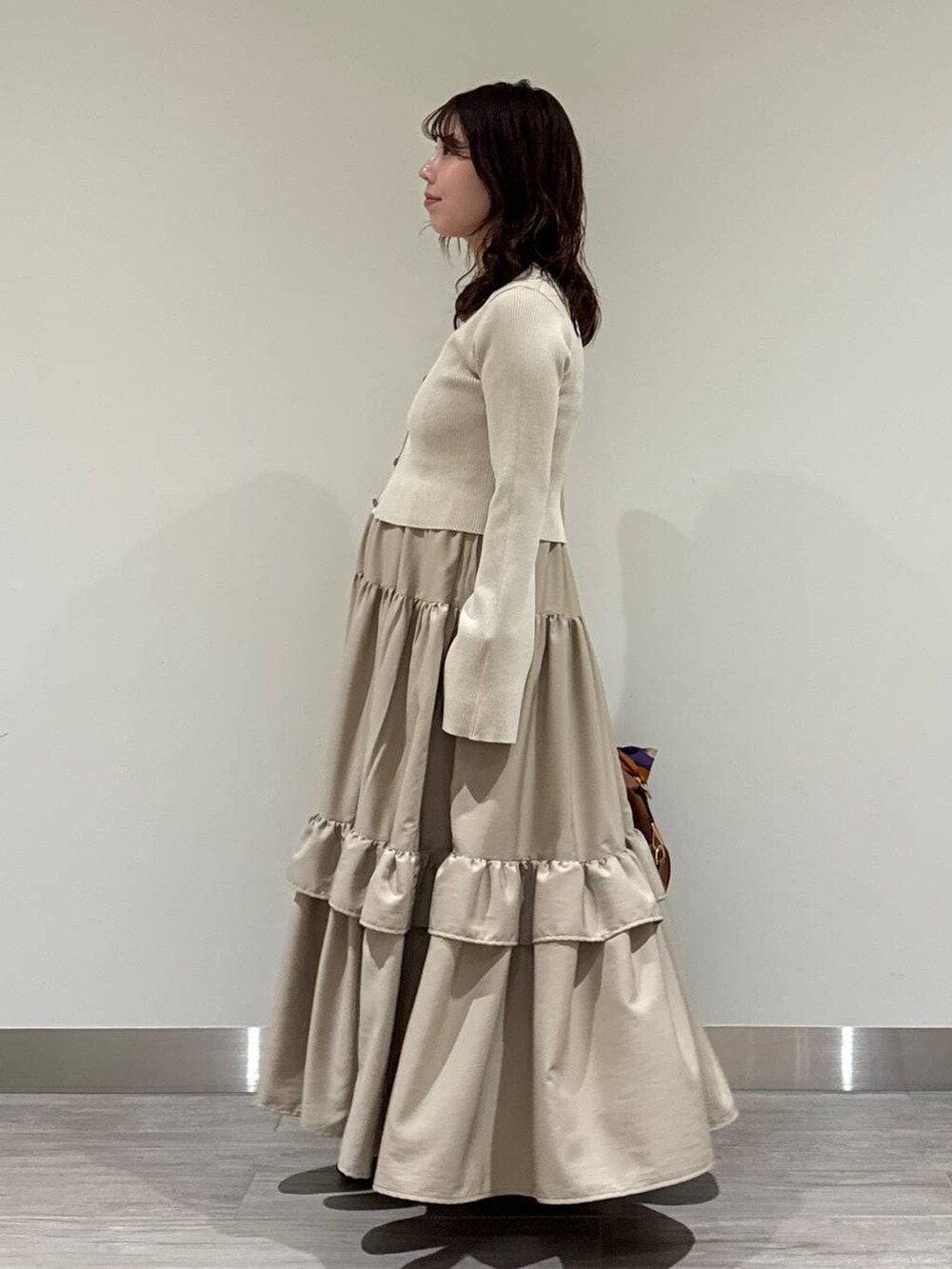 ブラウン系のボストンバッグ、ホワイト系のキャミソール、ブラウン系のローファーを着用したレディースの冬コーディネートの4枚目の写真