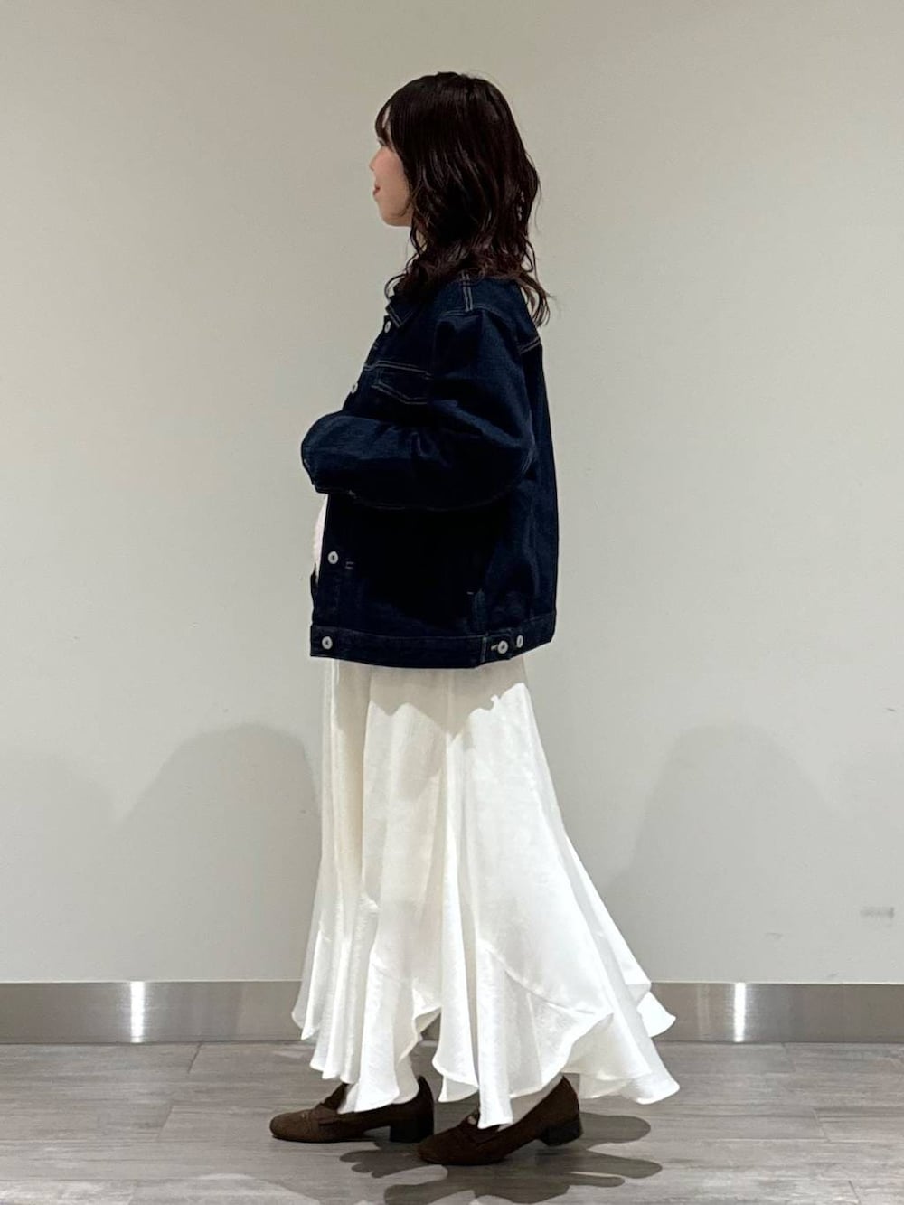 ベージュ系のハンドバッグ、ブラウン系のローファー、ピンク系のニット/セーターを着用したレディースの冬コーディネートの3枚目の写真