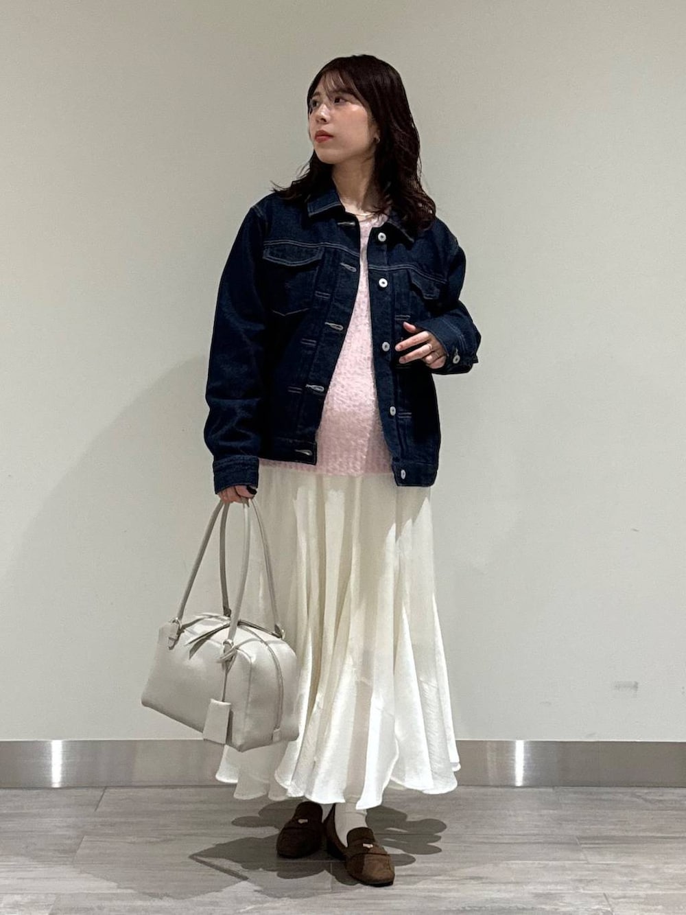 ベージュ系のハンドバッグ、ブラウン系のローファー、ピンク系のニット/セーターを着用したレディースの冬コーディネートの5枚目の写真