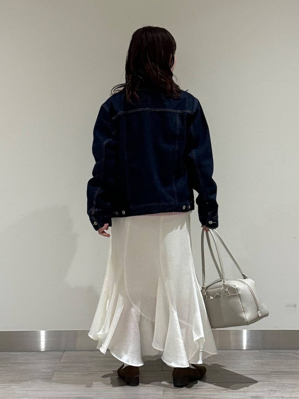 ベージュ系のハンドバッグ、ブラウン系のローファー、ピンク系のニット/セーターを着用したレディースの冬コーディネートの4枚目の写真