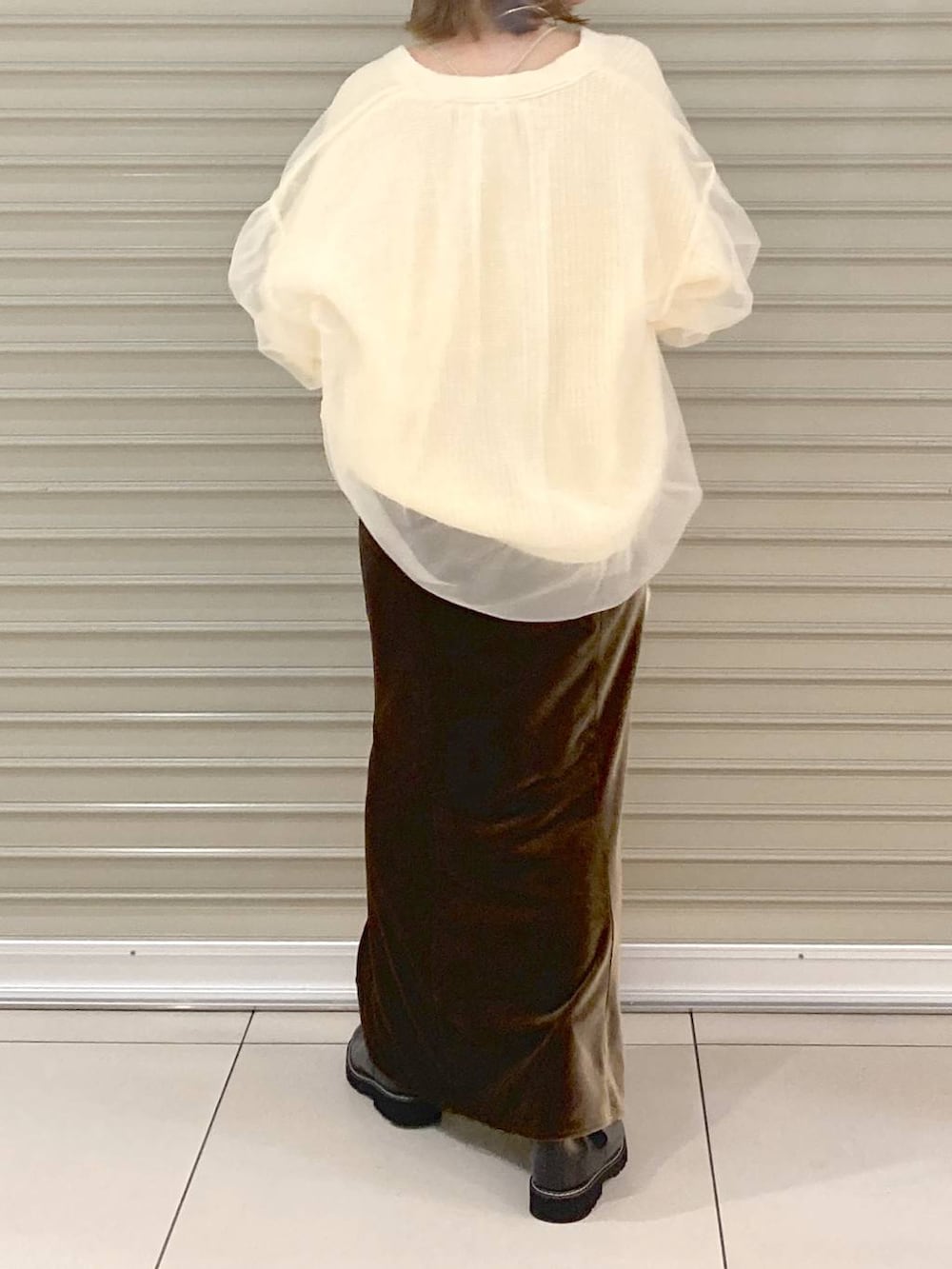 ベージュ系のキャミソール、ホワイト系のカーディガン/ボレロ、ブラウン系のスカートを着用したレディースの秋コーディネートの3枚目の写真