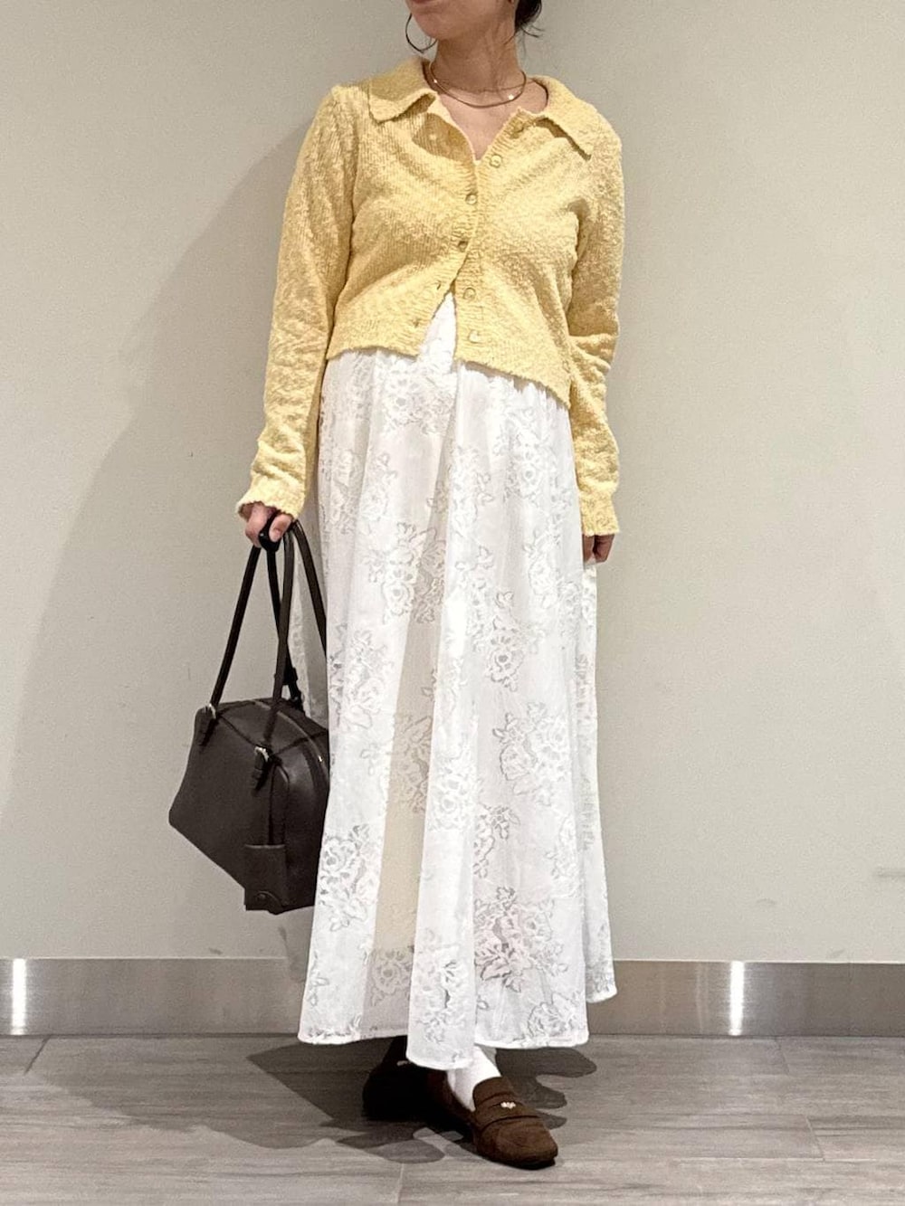 ブラウン系のハンドバッグ、ブラウン系のローファー、ホワイト系のワンピースを着用したレディースの春コーディネートの2枚目の写真