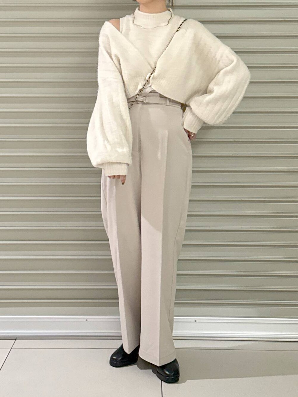 ブラック系のショルダーバッグ、ブラック系のブーツ、ホワイト系のその他パンツを着用したレディースの秋コーディネートの2枚目の写真