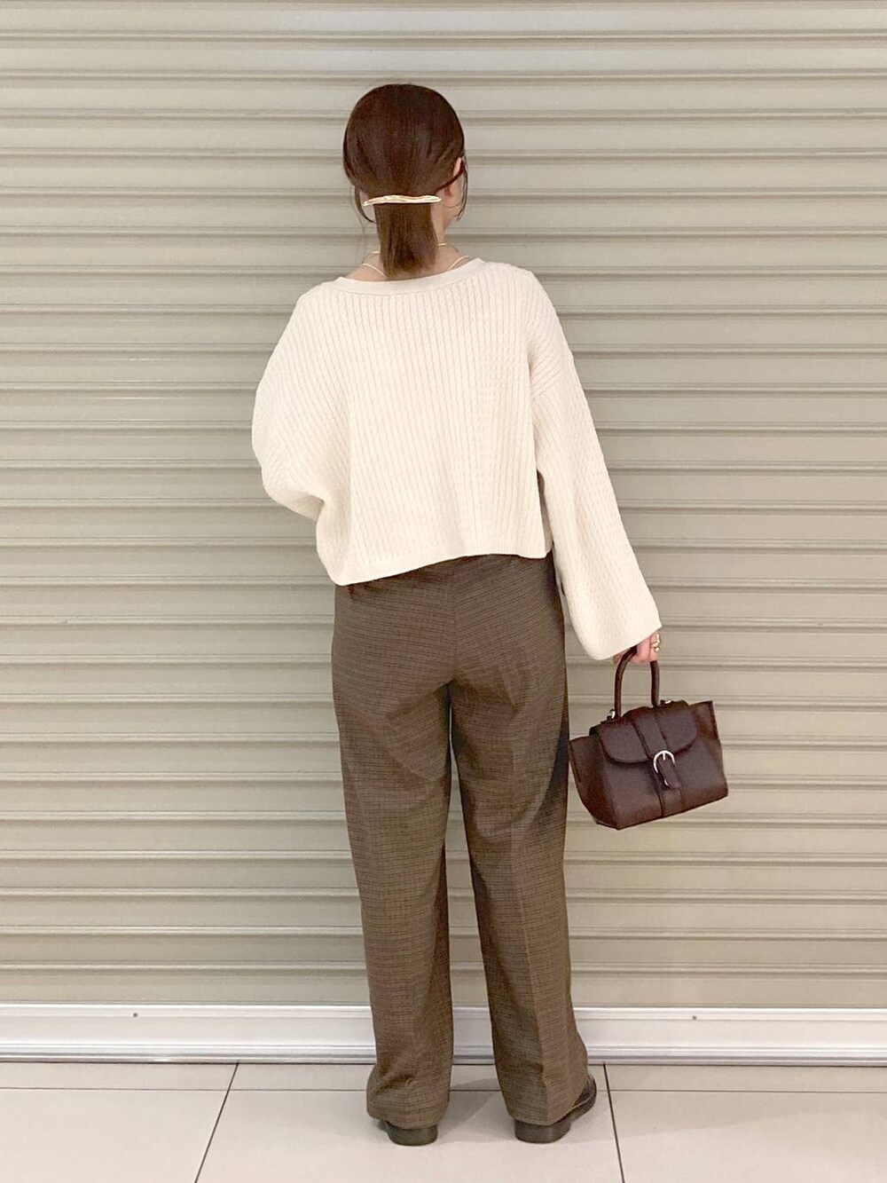 ホワイト系のタンクトップ、ブラウン系のハンドバッグ、ホワイト系のカーディガン/ボレロを着用したレディースの秋コーディネートの3枚目の写真