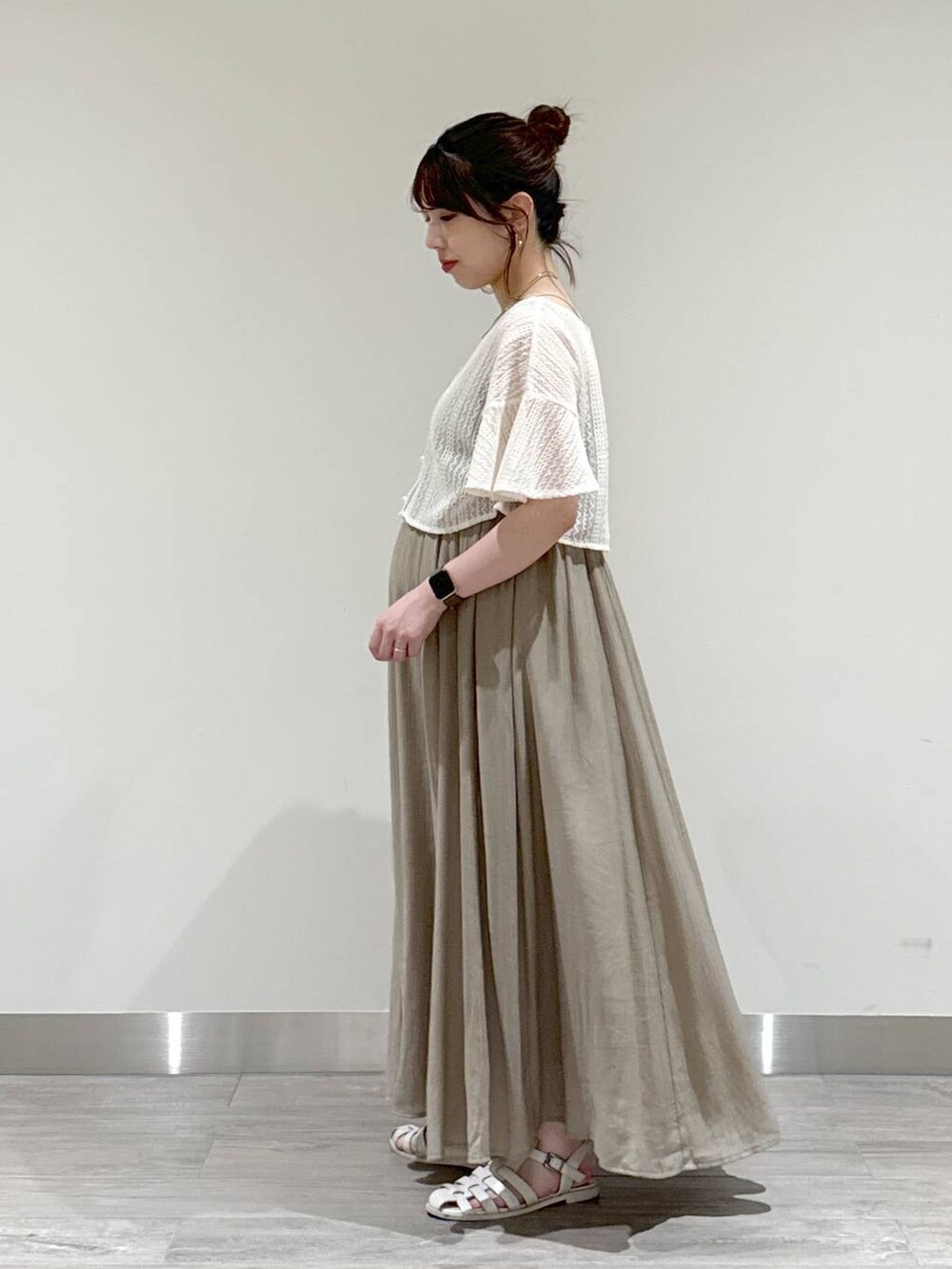 ホワイト系のカーディガン/ボレロ、グリーン系のワンピース、ホワイト系のショルダーバッグを着用したレディースの夏コーディネートの3枚目の写真