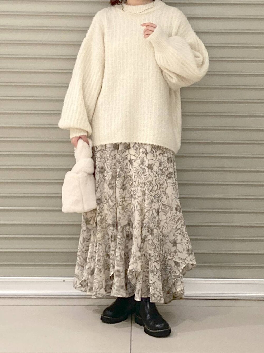 ブラック系のブーツ、ホワイト系のニット/セーター、ホワイト系のスカートを着用したレディースの冬コーディネートの4枚目の写真