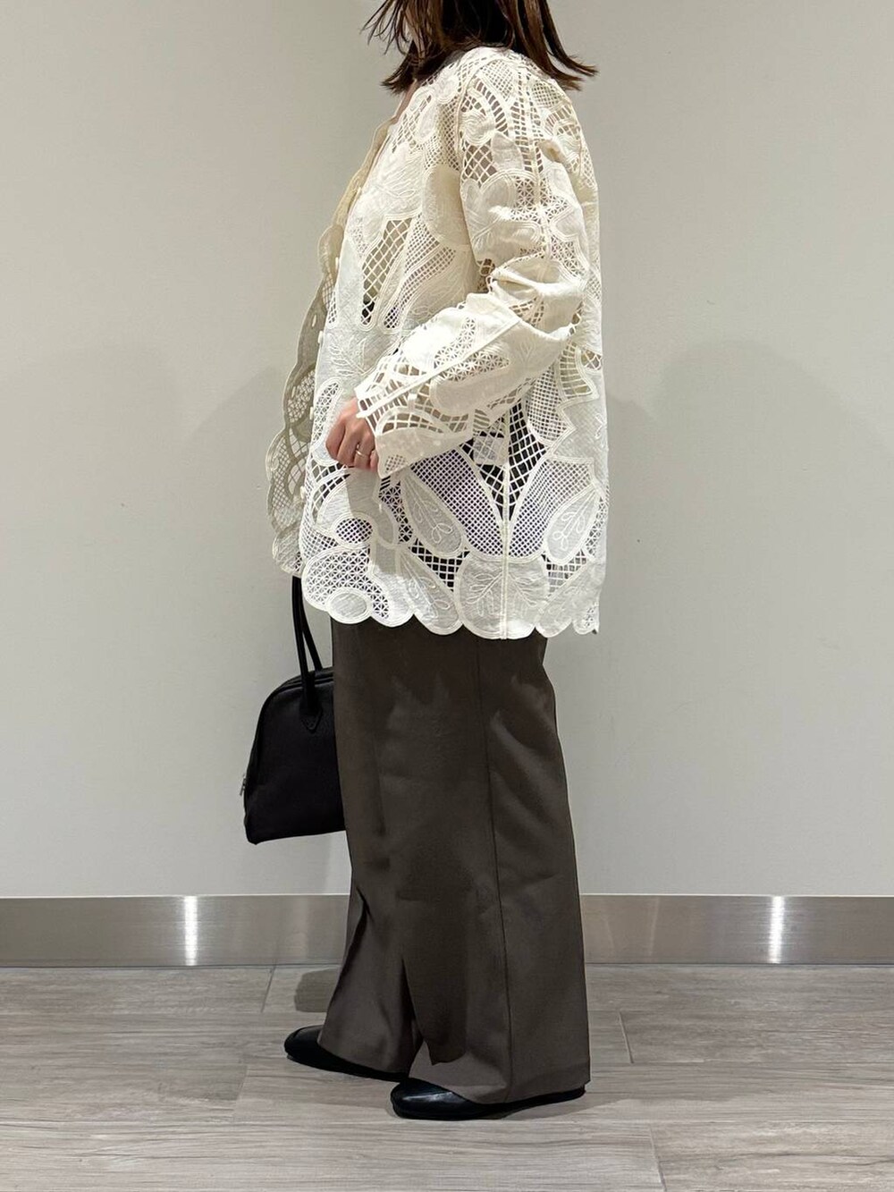 ホワイト系のキャミソール、ホワイト系のシャツ/ブラウス、ブラウン系のスラックスを着用したレディースの秋コーディネートの4枚目の写真