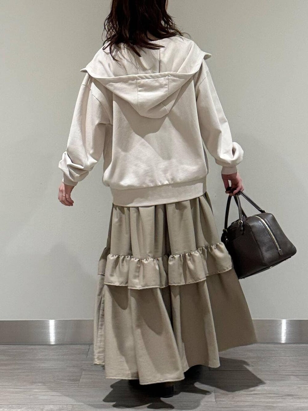 ホワイト系のキャミソール、ブラウン系のハンドバッグ、ブラウン系のローファーを着用したレディースの冬コーディネートの4枚目の写真