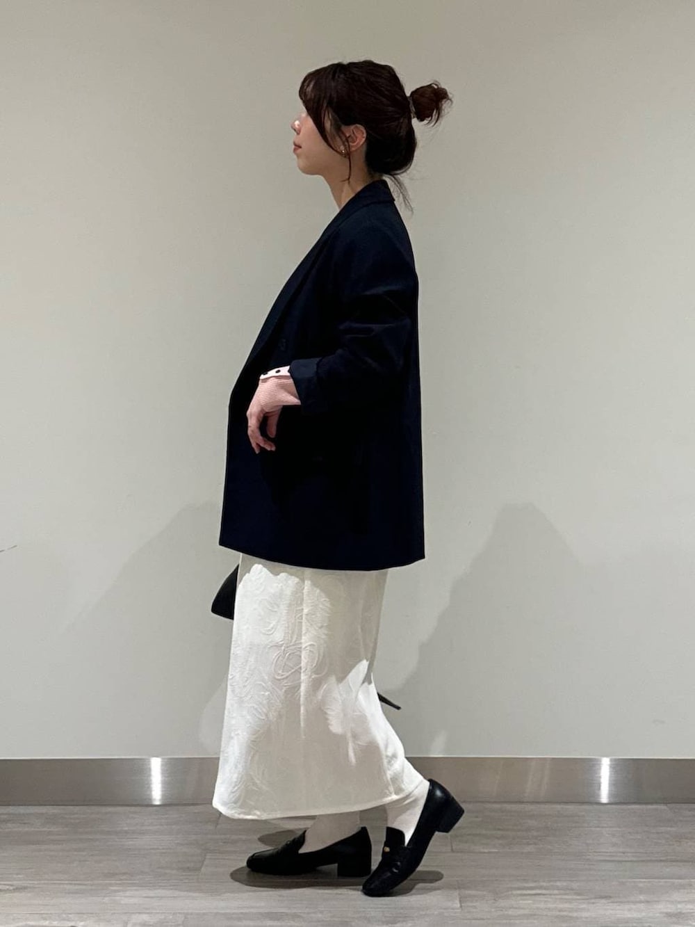 ブラック系のローファー、ブルー系のテーラードジャケット、ピンク系のニット/セーターを着用したレディースの春コーディネートの2枚目の写真