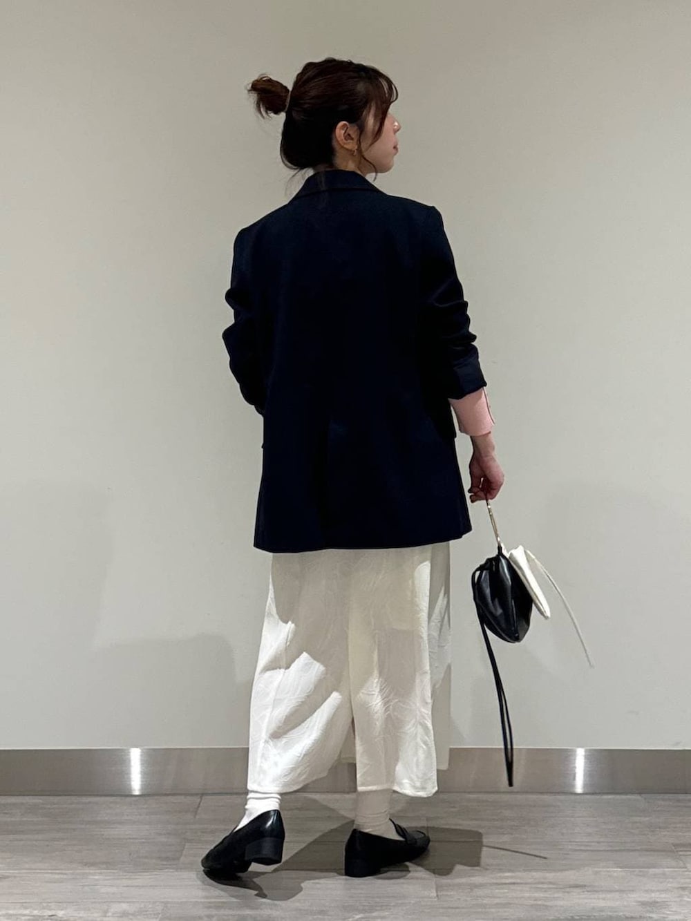 ブラック系のローファー、ブルー系のテーラードジャケット、ピンク系のニット/セーターを着用したレディースの春コーディネートの3枚目の写真