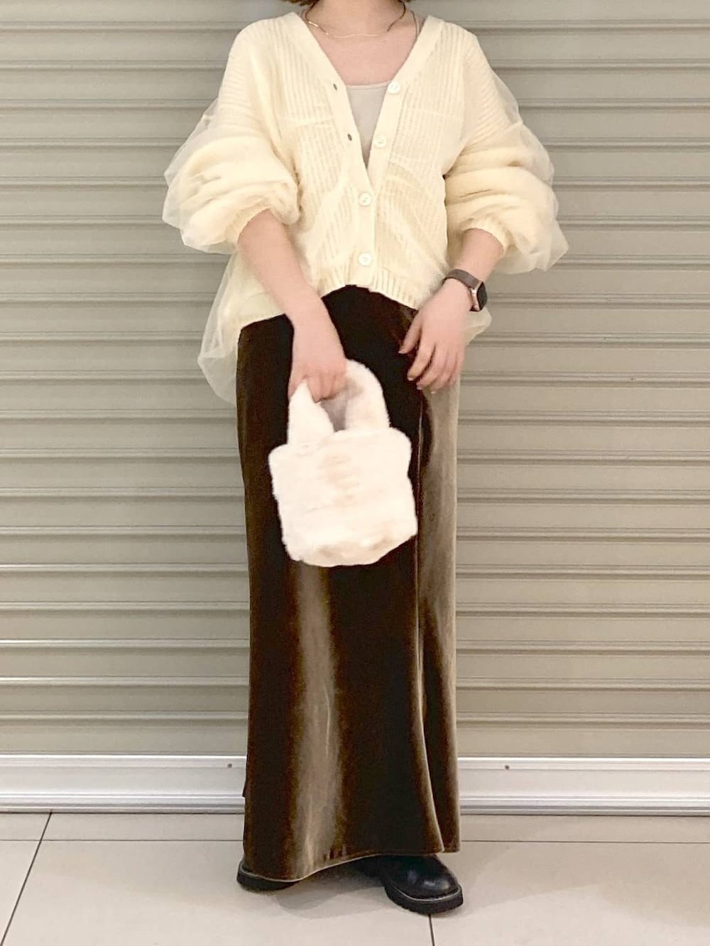 ベージュ系のキャミソール、ホワイト系のカーディガン/ボレロ、ブラウン系のスカートを着用したレディースの秋コーディネートの4枚目の写真