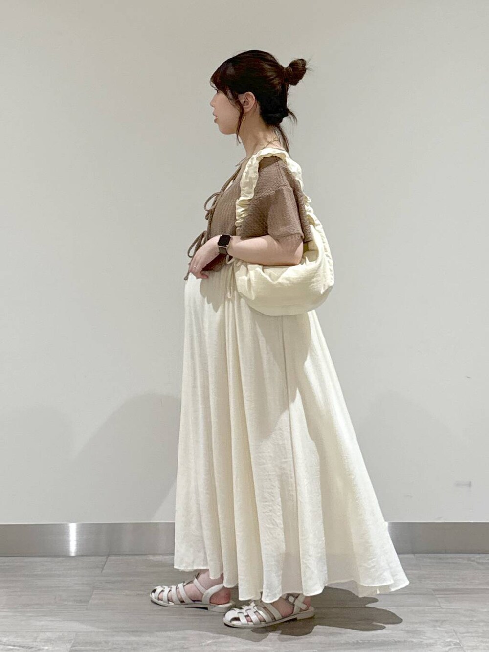 ホワイト系のショルダーバッグ、ブラウン系のカーディガン/ボレロ、ホワイト系のワンピースを着用したレディースの夏コーディネートの4枚目の写真