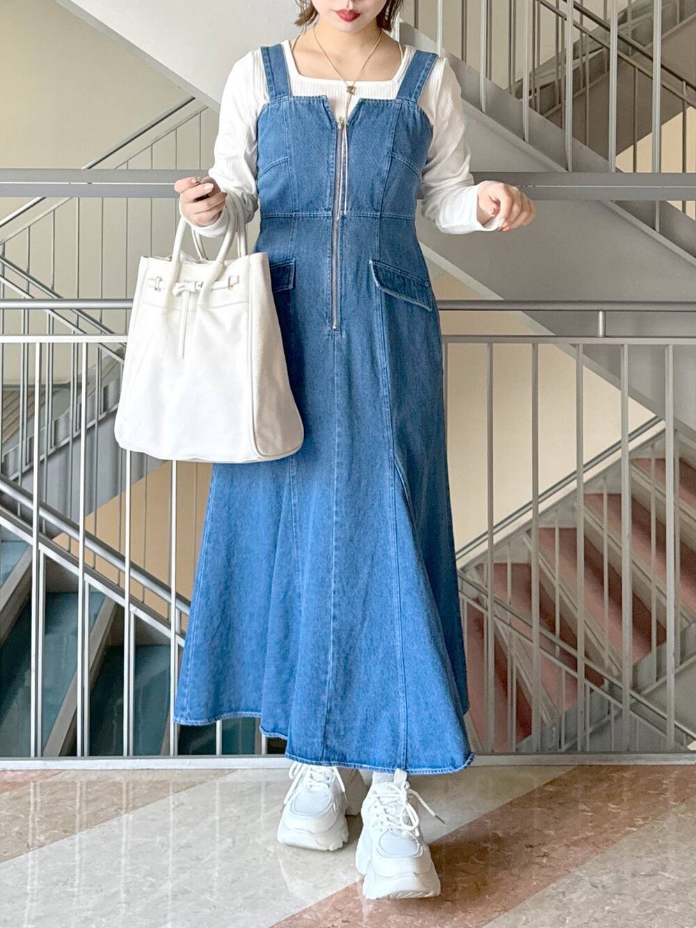 ホワイト系のトートバッグ、ホワイト系のTシャツ/カットソー、ホワイト系のスニーカーを着用したレディースの冬コーディネートの2枚目の写真