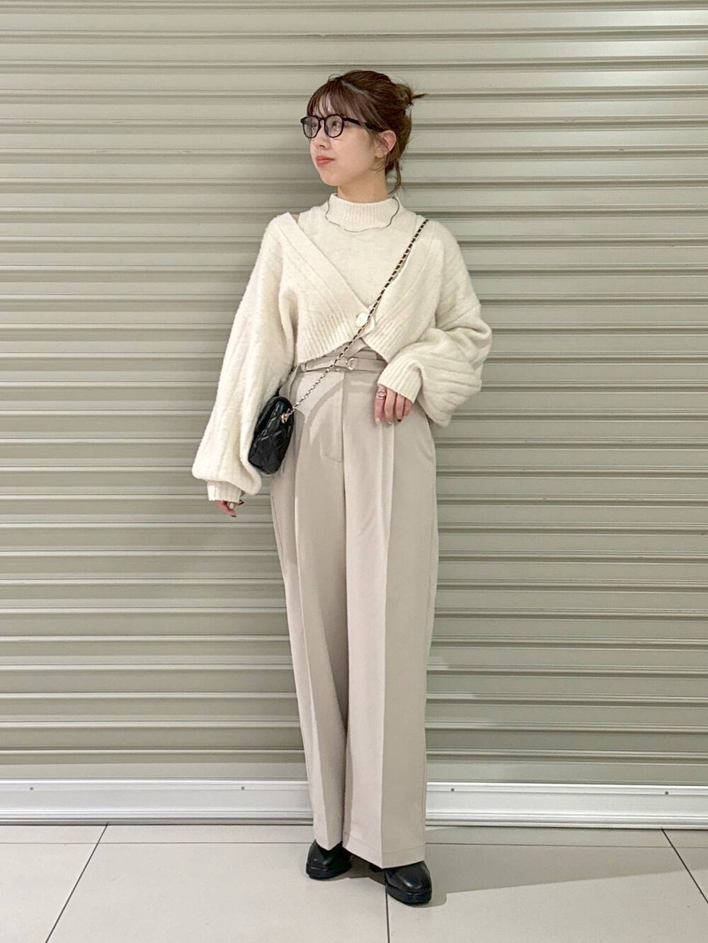 ブラック系のショルダーバッグ、ブラック系のブーツ、ホワイト系のその他パンツを着用したレディースの秋コーディネートの6枚目の写真