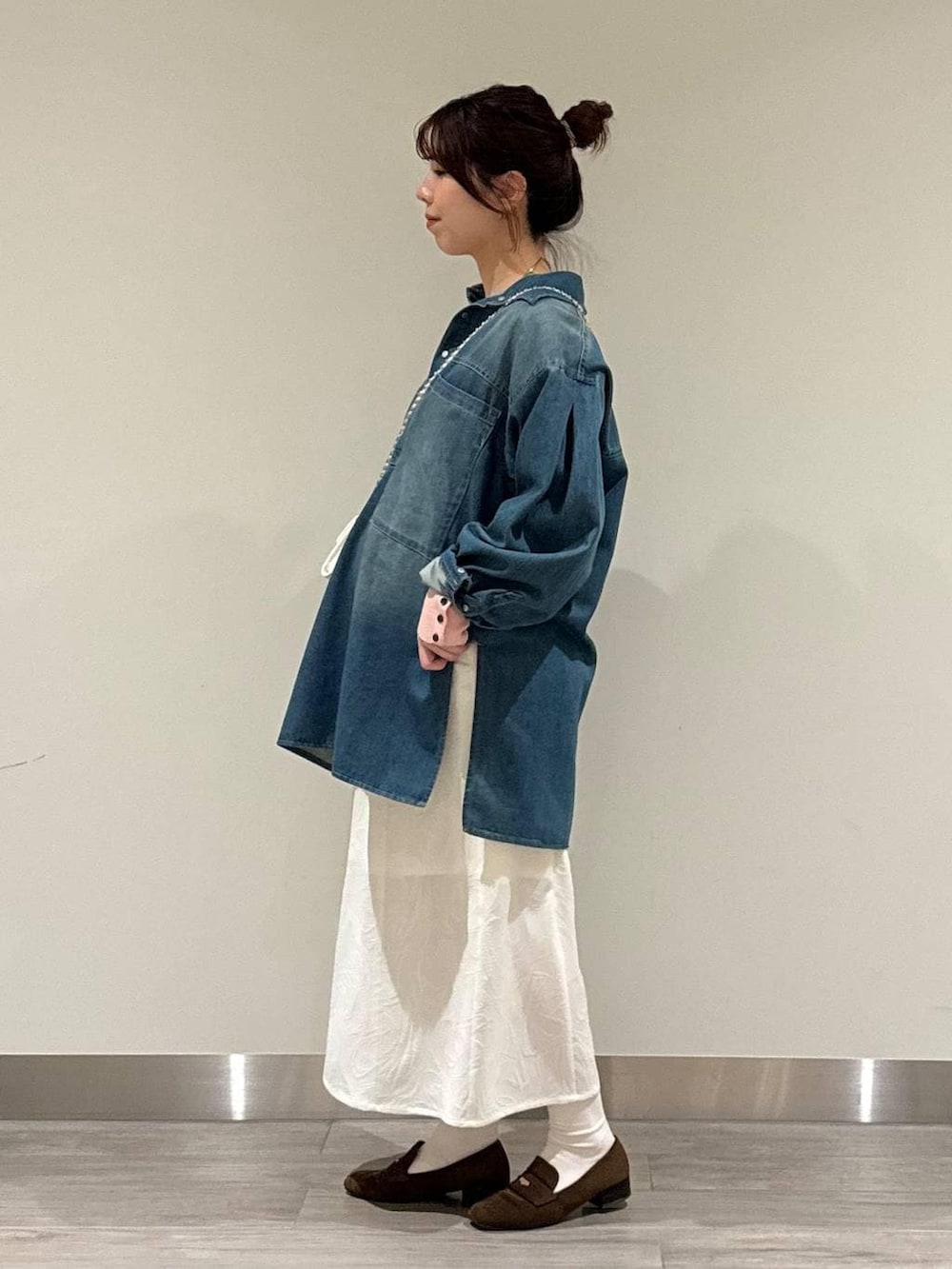 ブラウン系のローファー、ピンク系のニット/セーター、ホワイト系のワンピースを着用したレディースの春コーディネートの3枚目の写真