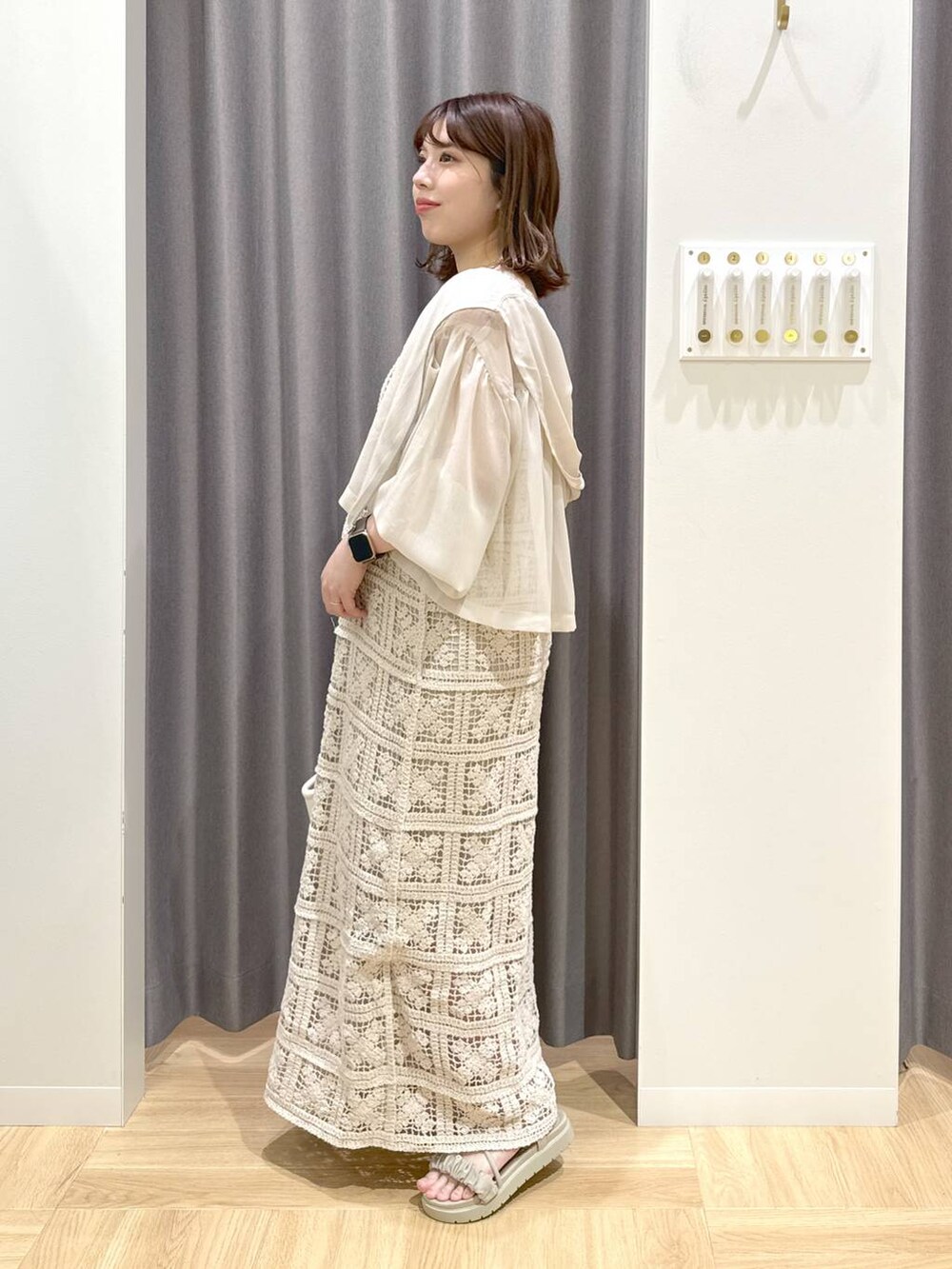 グレー系のサンダル、ホワイト系のハンドバッグ、ブルー系のタンクトップを着用したレディースの夏コーディネートの2枚目の写真