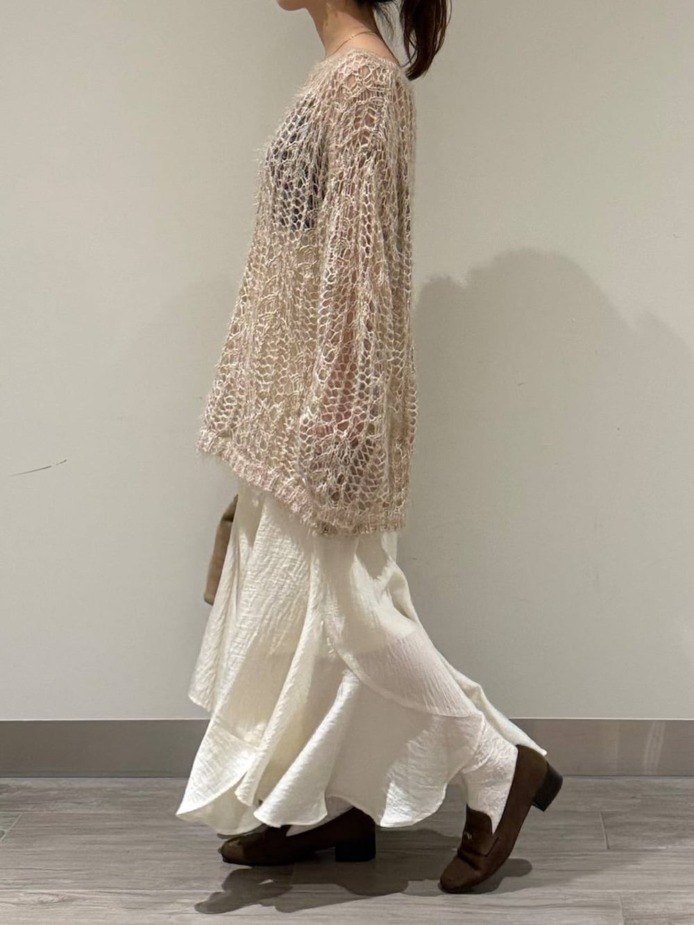 ベージュ系のニット/セーター、ホワイト系のスカート、ブラウン系のローファーを着用したレディースの秋コーディネートの4枚目の写真