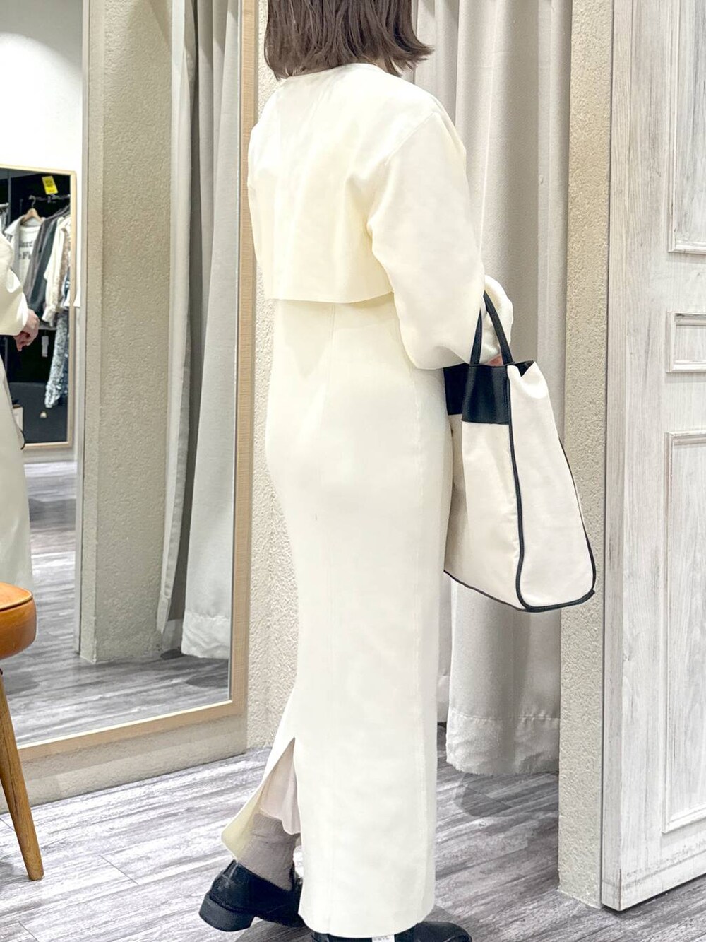 ブラック系のトートバッグ、ホワイト系のワンピース、ブラック系のローファーを着用したレディースの冬コーディネートの2枚目の写真