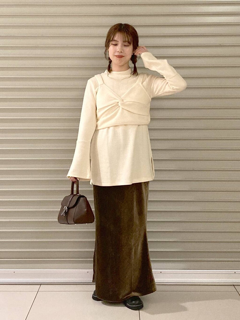ホワイト系のTシャツ/カットソー、ブラウン系のハンドバッグ、ブラック系のブーツを着用したレディースの秋コーディネートの4枚目の写真
