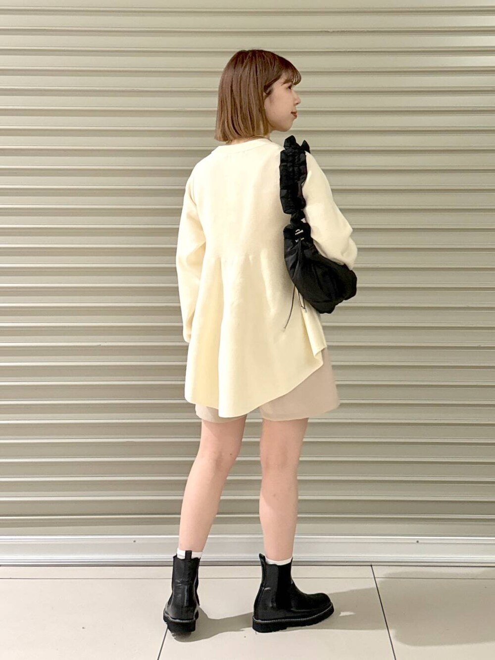 ブラック系のハンドバッグ、ブラック系のブーツ、ベージュ系のその他パンツを着用したレディースの冬コーディネートの4枚目の写真