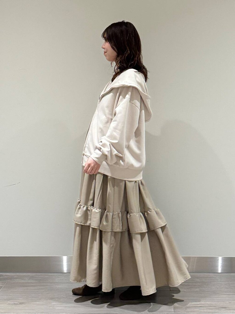 ホワイト系のキャミソール、ブラウン系のハンドバッグ、ブラウン系のローファーを着用したレディースの冬コーディネートの3枚目の写真