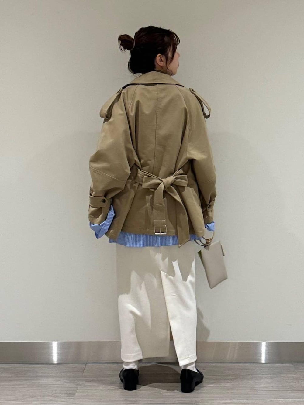 ブラック系のローファー、ベージュ系のトレンチコート、グレー系のニット/セーターを着用したレディースの春コーディネートの3枚目の写真